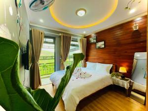 een slaapkamer met een bed en een groene stoel bij Pine Forest House Dalat in Xuan An