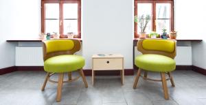 two chairs with green seats in a room with windows at 8pokoi OFKA in Cieszyn