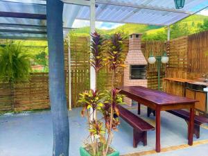 a patio with a wooden table and a fireplace at Pousada Villa Três in Serra Negra