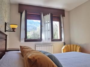 1 dormitorio con 1 cama y 2 ventanas en Casa Rural El Gidio, en Parres de Llanes