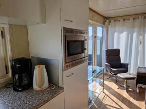 a kitchen with a microwave and a chair in a room at kreeft 171 in Ballum