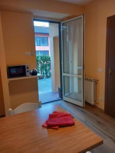 Habitación con mesa y puerta corredera de cristal en Sunshine GuestHouse, en Cannero Riviera