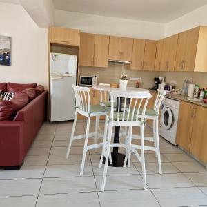cocina con mesa, sillas y nevera en PERNERA 33 Beach House, en Protaras