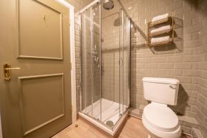 a bathroom with a toilet and a glass shower at Woodroffe Arms, Hope Room 4 in Hope