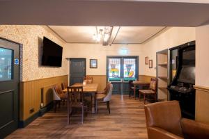 a dining room with tables and chairs and a television at Woodroffe Arms, Hope Room 4 in Hope