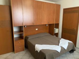 1 dormitorio con 1 cama y armarios de madera en Residence Giulia en Santa Maria Maddalena