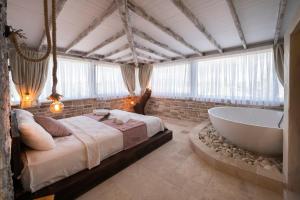 a bedroom with a large bed and a bath tub at K Bozcaada Revma in Bozcaada