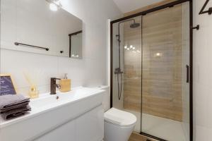 a bathroom with a shower and a toilet and a sink at Indigo Guest House in Lagos