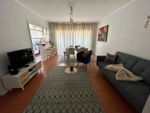 - un salon avec un canapé bleu et une table dans l'établissement Divine Waves - Cabedelo, à Viana do Castelo