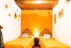 2 camas en una habitación pequeña con sábanas amarillas en LE STREGHE rooms e art con garage en Livorno