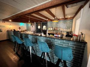 a bar with blue bar stools in a restaurant at KempenLodge, luxe boshuis voor 8 pers, in Brabantse natuur in Diessen