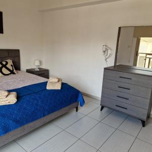 1 dormitorio con 1 cama y vestidor con espejo en PERNERA 33 Beach House, en Protaras