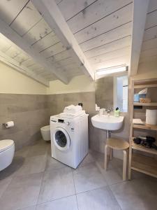 ein Badezimmer mit einer Waschmaschine und einem Waschbecken in der Unterkunft Aparthotel All'Orologio in Peschiera del Garda