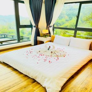 a bed with red rose petals on it at Pine Forest House Dalat in Xuan An