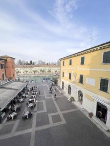 uma rua da cidade com muitas mesas e edifícios em Aparthotel All'Orologio em Peschiera del Garda