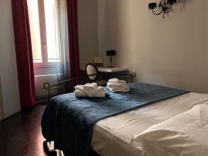 um quarto com uma cama com duas toalhas em Piazza Maggiore Luxury Apartment em Bolonha