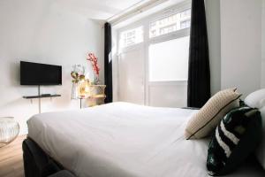 um quarto com uma grande cama branca e uma janela em HSH Traversière-Boulogne-Billancourt I Appartement 4P em Boulogne-Billancourt