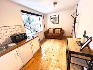 a kitchen and living room with a table and a microwave at Flat 4, 10 St John's in Bournemouth