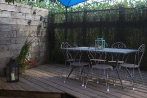 une table et des chaises assises sur une terrasse en bois dans l'établissement Alaudy Vacances Séjours écologiques - 3 gites, à Ossages