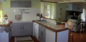 - une cuisine avec un évier et un comptoir dans l'établissement Alaudy Vacances Séjours écologiques - 3 gites, à Ossages