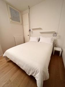 un grande letto bianco in una stanza con tavolo di Koro's Apartments a Bologna