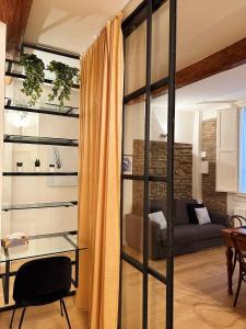 soggiorno con parete in vetro e divano di Koro's Apartments a Bologna