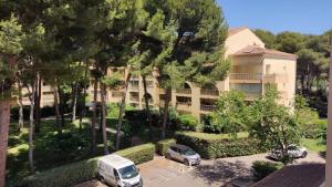 een appartementencomplex met auto's geparkeerd op een parkeerplaats bij Bel appartement avec piscine proche des plages in Six-Fours-les-Plages