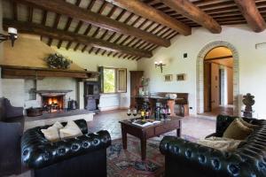 a living room with leather furniture and a fireplace at Valle di Assisi Country Apartments in Assisi
