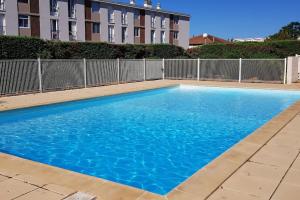 niebieski basen przed budynkiem w obiekcie Riviera avec piscine w mieście La Seyne-sur-Mer