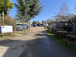 una calle con un banco, mesas y un edificio en The Roade House, en Northampton