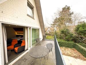 a balcony with a bed and a table and chairs at Villa Vindina in De Panne