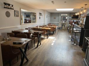 een eetkamer met houten tafels en stoelen bij The Roade House in Northampton