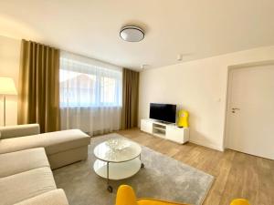 a living room with a couch and a table and a tv at Apartmán Samuel Prievidza in Prievidza