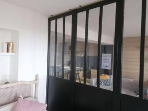 un armario negro con puertas de cristal en un dormitorio en Tamarina, en Guéthary