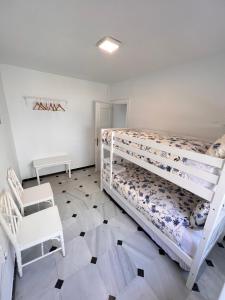 sypialnia z łóżkiem piętrowym i krzesłem w obiekcie Pedregalejo Playa, Piscina y Parking w Maladze +24 zdjęcia