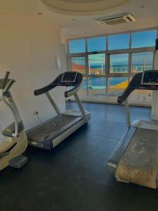 a gym with two treadmill machines and a large window at Ocean Oasis 2Br Condo in Dar es Salaam