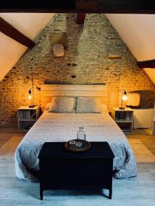 - une chambre avec un lit et un mur en pierre dans l'établissement Le Cottage des Chalands, à Saint-Georges-sur-Cher