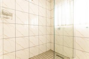 y baño con ducha y azulejos de mármol. en Nyathi Lodge, en Richards Bay