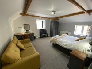 een slaapkamer met een bed en een bank bij The Roade House in Northampton