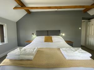 a bedroom with a large bed with two towels on it at The Roade House Rooms in Roade