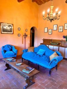 a living room with a blue couch and a table at Winery Houses in Chianti in Mercatale Val Di Pesa