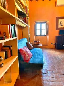 a living room with a blue couch and a book shelf at Winery Houses in Chianti in Mercatale Val Di Pesa