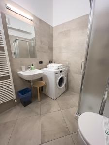 uma casa de banho com uma máquina de lavar roupa e um lavatório em Aparthotel All'Orologio em Peschiera del Garda