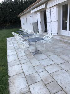 een groep tafels en stoelen op een patio bij Maison neuve 8 couchages in Ginestet