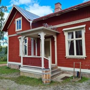 a red house with a porch and stairs in front of it at Conciërgewoning van het gerechtsgebouw. in Ragunda