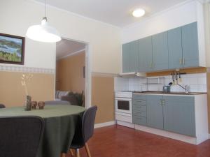 a kitchen with a table and a kitchen with blue cabinets at Conciërgewoning van het gerechtsgebouw. in Ragunda