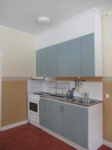 a kitchen with blue cabinets and a sink at Conciërgewoning van het gerechtsgebouw. in Ragunda +16 photos