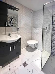 y baño con aseo, lavabo y ducha. en GH Moonlight en Sarajevo