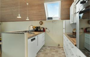 a kitchen with white cabinets and a sink and a window at Three-Bedroom Holiday Home In Otterup in Otterup