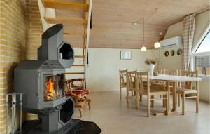 オテルプにあるStunning Home In Otterup With 3 Bedrooms And Wifiの暖炉付きのリビングルーム(テーブル、椅子付)
